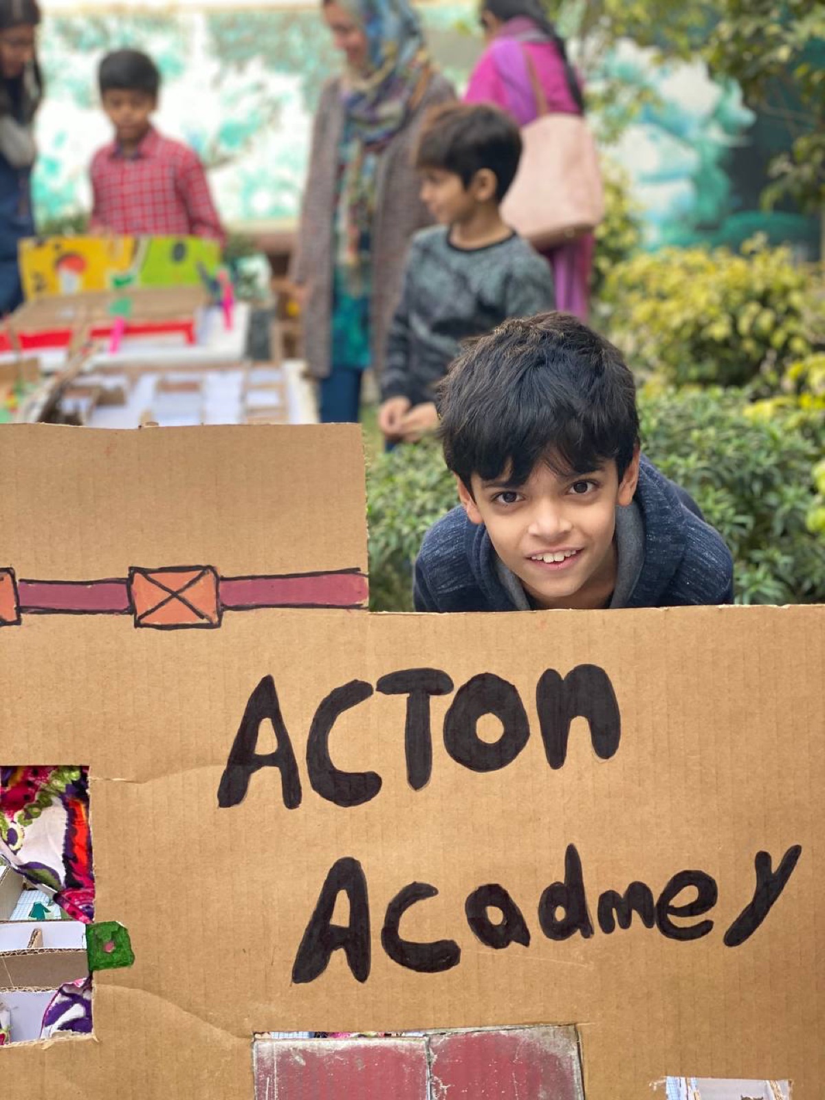 Young learner proudly showing his Acton Academy project